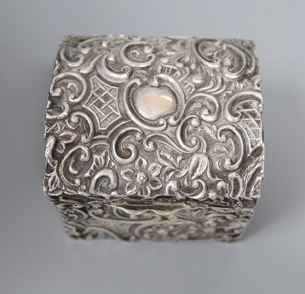 A late Victorian embossed silver serviette ring box, containing two serviette rings, Henry Matthews, Birmingham, 1892